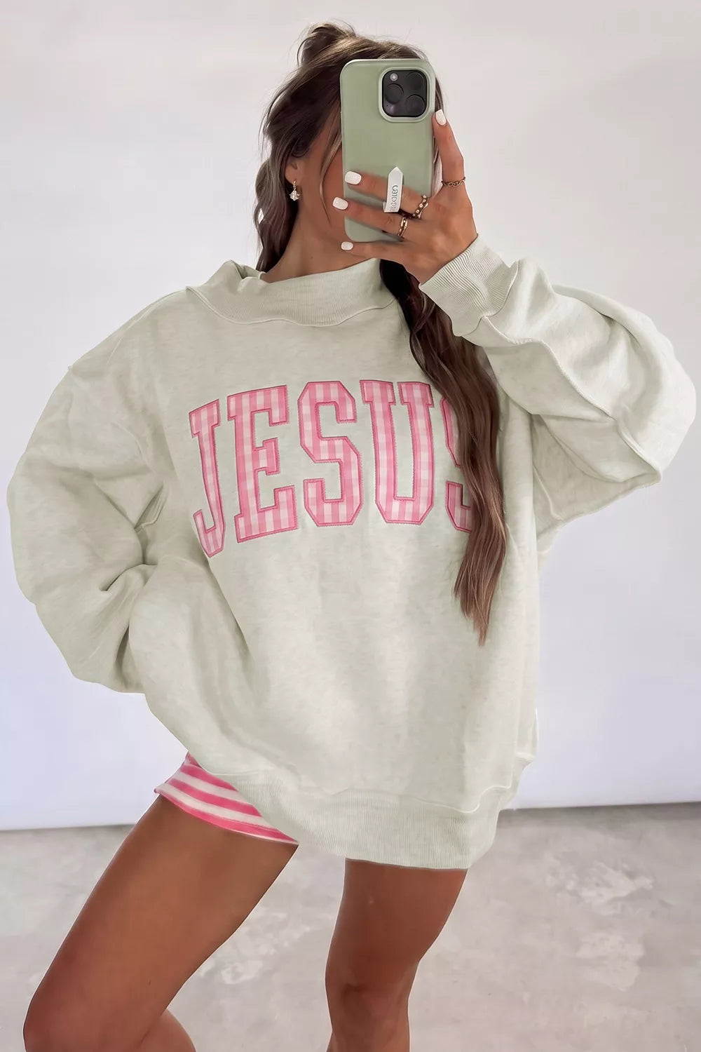 oversized cream sweatshirt with large pink striped JESUS lettering