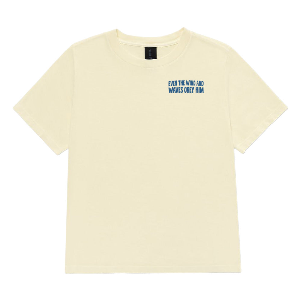 A butter yellow short-sleeve t-shirt with blue text on the left chest reading 'EVER THE WIND AND WAVES OBEY HIM'.