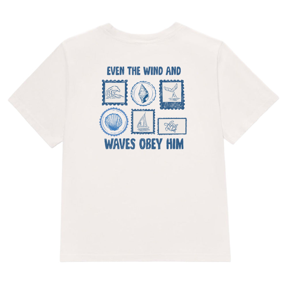 An off-white short-sleeve t-shirt with a blue graphic print on the front. The graphic features the text 'EVEN THE WIND AND WAVES OBELY HIM' surrounding a grid of six blue nautical-themed illustrations, including a wave, a seashell, a sailboat, and a compass.