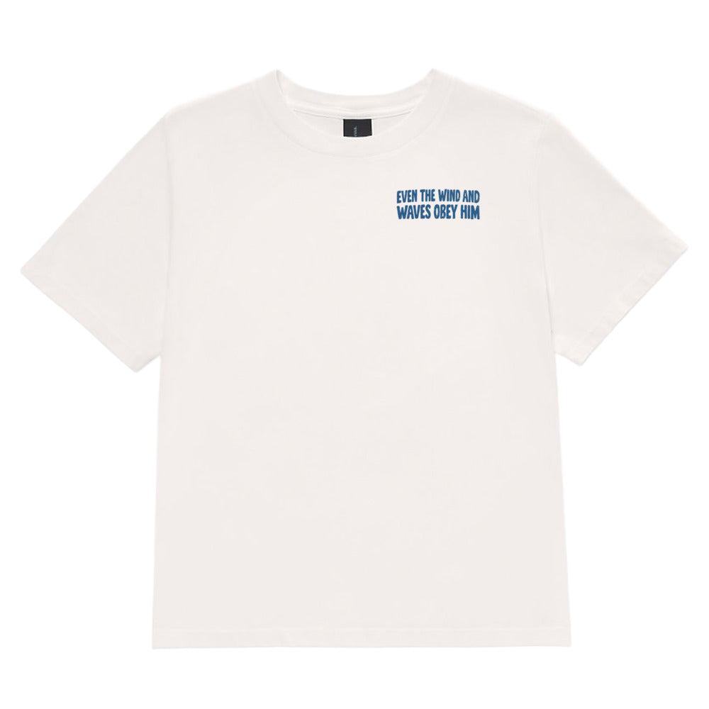 An off-white short-sleeve crewneck t-shirt with blue text on the left chest reading 'EVEN THE WIND AND WAVES OBey OIM', displayed flat against a solid white background.