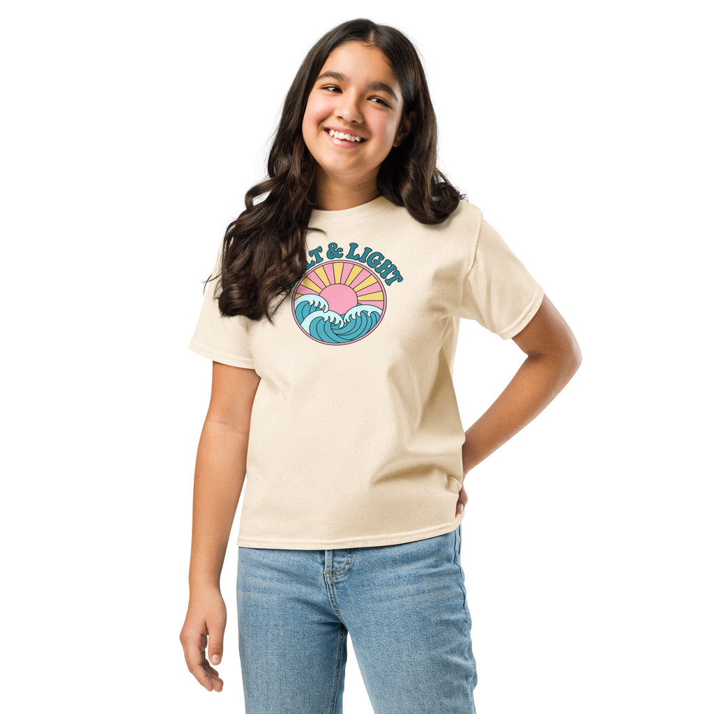 Girl wearing a beige “Salt & Light” Christian T-shirt with teal lettering, ocean waves, and a yellow sunburst